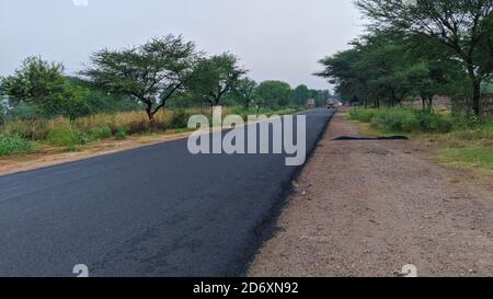 18. Oktober 2020 : Reengus, Jaipur, Indien / Grünes Feld und blauer Himmel, Straße in der indischen Landschaft, Reise mit dem Fahrrad, Autobahn Indien, indische Landschaft, summ Stockfoto