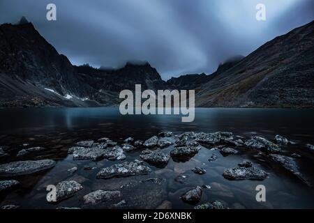 Wunderschöne dramatische Aussicht auf die Rugged Mountains und den Alpinen See Dämmerung Stockfoto