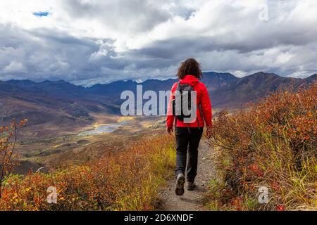 Malerische Aussicht auf Frau Wandern an einem wolkigen Herbsttag Stockfoto