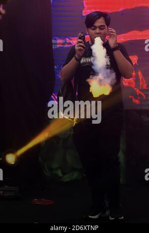 Fathiba, ein berühmter indonesischer Vape-Künstler, der Spaß mit Dämpfen hat, bevor er als Juror für einen Vape Cloud Trick Contest in Jakarta, Indonesien, fungiert. Stockfoto