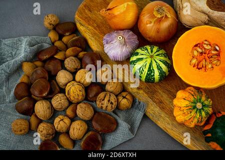 Still Life Herbst Konzept Bild mit Gemüse und Nüssen. Kürbis, Butternut, Kastanien, Herbstnüsse, Bogen, Knoblauch. Stockfoto