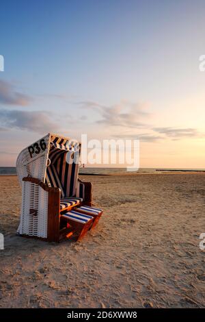 Sonnenaufgang an der Küste der Ostsee, der Strand Stuhl steht auf dem Sandstrand. Stockfoto