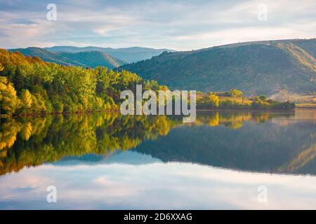 gilau See von cluj Land in Abendlicht. Schöne Landschaft von rumänien im Herbst. Reflexion auf der ruhigen Wasseroberfläche. Bäume in bunten Laub Stockfoto