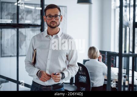 Portrait des jungen Geschäftsmannes in formeller Kleidung, die in steht Büro Stockfoto