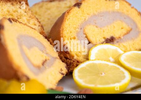 Brazo de gitano, typisch spanische schweizer Brötchen gefüllt mit Backcreme. Zitronenkuchen, klassisches Rezept, dekoriert mit getrockneten Früchten. Stockfoto