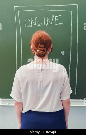 Lehrer an der Tür mit dem Text Online in Kreide auf einer Tafel gezeichnet. Konzept der Online-Bildung in der Schule. Stockfoto