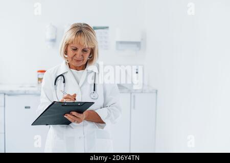 Porträt eines professionellen Oberarztes in der Klinik mit Notizblock in Hände Stockfoto