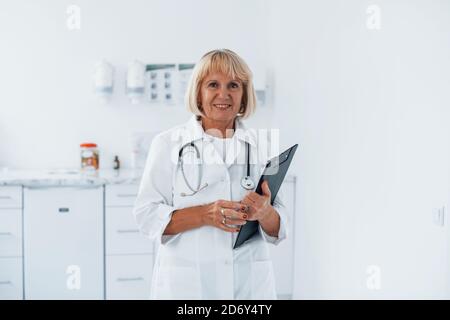 Porträt eines professionellen Oberarztes in der Klinik mit Notizblock in Hände Stockfoto