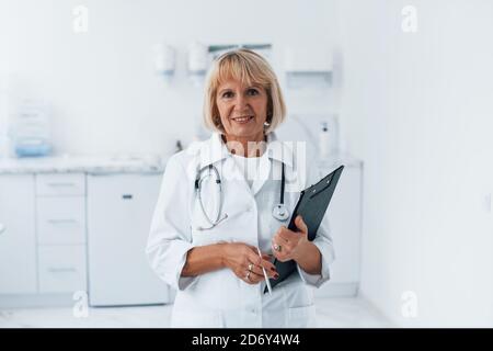 Porträt eines professionellen Oberarztes in der Klinik mit Notizblock in Hände Stockfoto