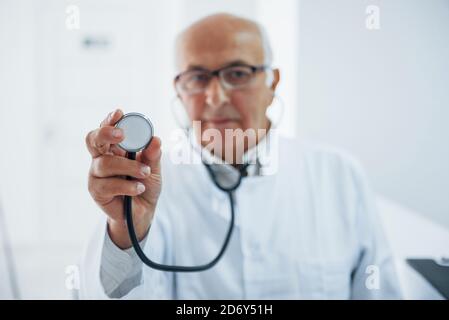 Porträt eines Oberarztes mit Stethoskop und in weißer Uniform Das steht in der Klinik Stockfoto