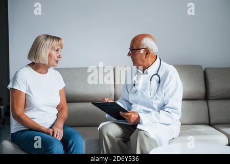 Ältere Frau haben Beratung in der Klinik durch den Mann Arzt Stockfoto