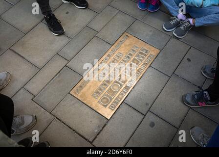 Gedenktafel zum Gedenken an den Tod des schwedischen Ministerpräsidenten Olof Palmer in Stockholm, mit Füßen von Menschen, die die Gedenktafel beobachten. Stockfoto