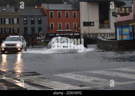 Fahrzeuge, die durch das Wasser der Überschwemmungen auf dem Wolfe Tone Square, Bantry Stadtlots, West Cork, Irland, fahren Stockfoto