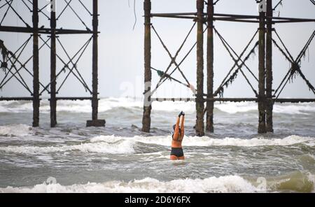 Brighton UK 20. Oktober 2020 - EINE Schwimmerin genießt ihr tägliches Bad im Meer in Brighton an einem luftigen, aber hellen Morgen bei Ebbe . Für die nächsten Tage in ganz Großbritannien werden die nassen und windigen Bedingungen prognostiziert, während sich Sturm Barbara aus Europa nähert : Credit Simon Dack / Alamy Live News Stockfoto