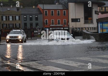 Fahrzeuge, die durch das Wasser der Überschwemmungen auf dem Wolfe Tone Square, Bantry Stadtlots, West Cork, Irland, fahren Stockfoto