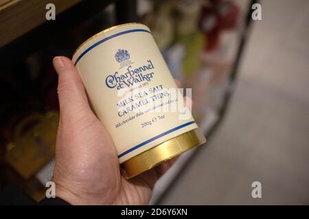 Hand hält eine Dose Charbonnel et Walker' Milk Sea Salt Karamelldosen. Charbonnel et Walker ist ein Unternehmen der Schokoladenhersteller mit Sitz in Bond St, London Stockfoto