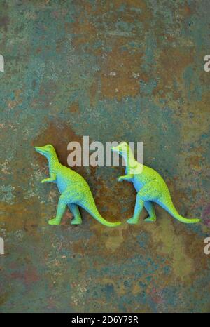 Zwei Modelle von Dinosauriern Tyrannosaurus mit blauen Körpern und Kalk Grüne Rücken gehen in der Schlange Stockfoto