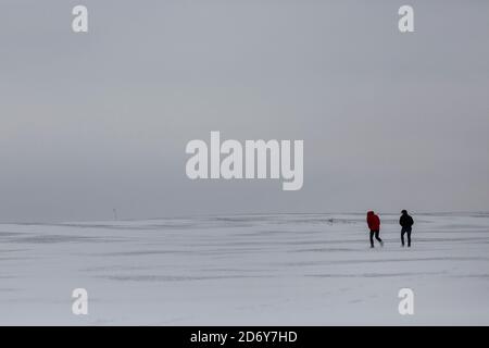 Zwei Wanderer in der Ferne zu Fuß über eine schneebedeckte Landschaft in Großbritannien nach dem Tier aus dem Osten Schneesturm Stockfoto