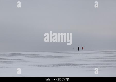 Zwei Wanderer in der Ferne zu Fuß über eine schneebedeckte Landschaft in Großbritannien nach dem Tier aus dem Osten Schneesturm Stockfoto