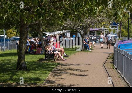 Urlauber genießen die Sonne, während sie sich in den Trenance Gardens in Newquay in Cornwall entspannen. Stockfoto