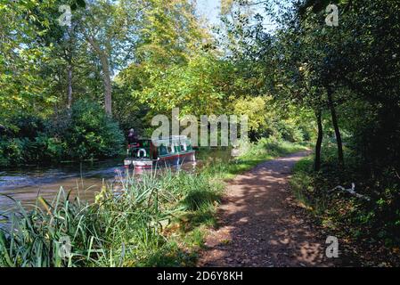 Ein schmales Boot auf dem Fluss Wey Navigation Kanal bei Byfleet an einem sonnigen Herbsttag, Surrey England UK Stockfoto