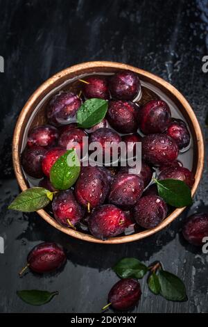 Frische reife Herbstpflaumen auf dunklem Hintergrund, Nahaufnahme Stockfoto