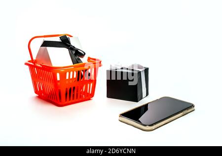 Online-Shopping-Konzept - Warenkorb, Tablet-pc oder Smartphone, Geschenkbox isoliert auf weißem Hintergrund. Platz für Text kopieren. Schwarzer freitag Stockfoto