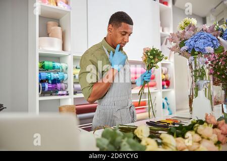Floristen Herstellung von frischen Blumensträußen und mit Smartphone Stockfoto