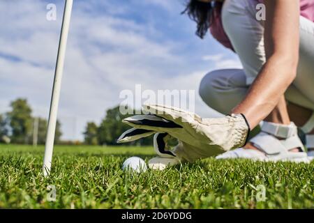 Golfer in einem Handschuh sitzt auf ihren Hacken Stockfoto