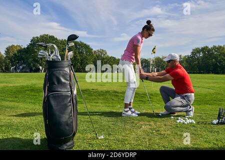 Anfänger Golfer üben einen Putting Schlaganfall mit ihrem Trainer Stockfoto