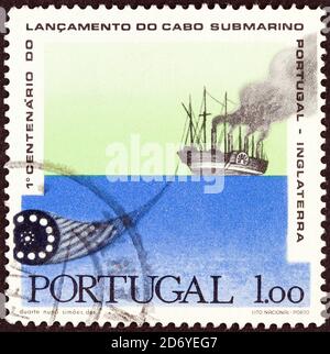 PORTUGAL - UM 1970: Eine in Portugal gedruckte Briefmarke, die zum 100. Jahrestag von Portugal-England Telegraph Cable ausgegeben wurde, zeigt das große östliche Legekabel. Stockfoto