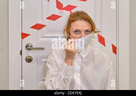 Die Frau entfernt die medizinische Maske aus ihrem Gesicht. Konzept der Beendigung der Quarantäne und Isolation von der Coronavirus-Epidemie Stockfoto