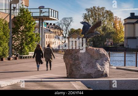 Zwei Frauen passieren eine wunderschöne Adlerstatue am Munktellbadet An einem schönen Herbsttag in Eskiltuna 2020 Oktober 19 Stockfoto
