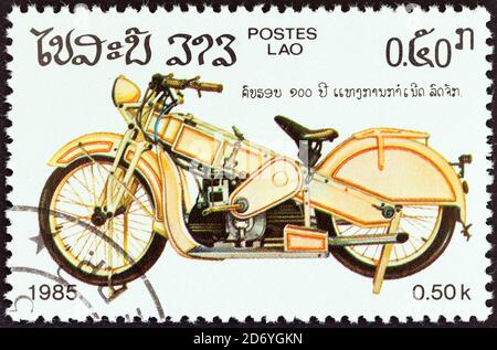 LAOS - UM 1985: Eine in Laos gedruckte Briefmarke aus der Ausgabe '100 Jahre Motorrad' zeigt ein Oldtimer-Motorrad, um 1985. Stockfoto