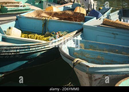 Alte blaue Fischerboote liegen im Hafen von La Cruz de Hunacaxtle, Mexiko. Die Morgensonne und das Meer sind bereit für den Frühaufsteher. Stockfoto