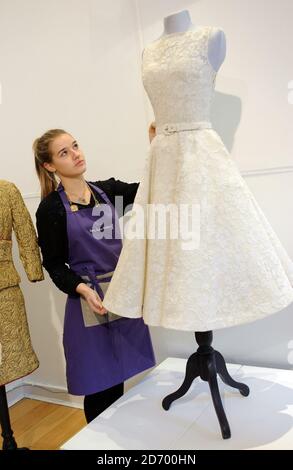 Lucy Bishop, Assistentin des Auktionshauses, verleiht dem Kleid von Audrey Hepburn den letzten Schliff, um 1954 ihren oscar zu sammeln, bei einer Besichtigung der Auktion Passion for Fashion von Kerry Taylor Auctions in der La Galleria in der Pall Mall im Zentrum von London. Das Kleid wird voraussichtlich bis zu Â£60,000 holen. Stockfoto