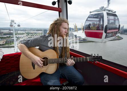 Newton Faulkner performt einen exklusiven Gig über London, auf einer der Olympic Emirates Air Cable Cars. Stockfoto