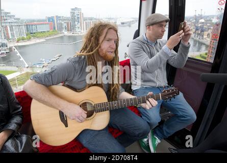 Newton Faulkner performt einen exklusiven Gig über London, auf einer der Olympic Emirates Air Cable Cars. Stockfoto