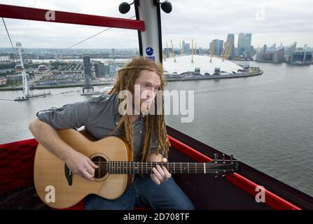 Newton Faulkner performt einen exklusiven Gig über London, auf einer der Olympic Emirates Air Cable Cars. Stockfoto