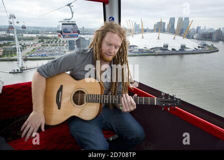 Newton Faulkner performt einen exklusiven Gig über London, auf einer der Olympic Emirates Air Cable Cars. Stockfoto