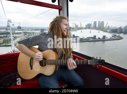 Newton Faulkner performt einen exklusiven Gig über London, auf einer der Olympic Emirates Air Cable Cars. Stockfoto