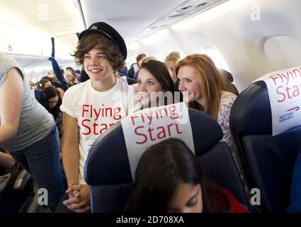 Harry Styles of One Direction an Bord von Flug BA1D - ein privater Charterflug von London nach Manchester, veranstaltet von der Band für die Gewinner des Wettbewerbs, die Â£50,000 für Flying Start - British Airways Wohltätigkeitsorganisation mit Comic Relief gesammelt. Stockfoto