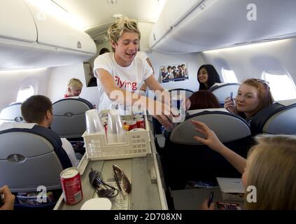 Niall Horan von One Direction serviert Getränke an Bord von Flug BA1D - einem privaten Charterflug von London nach Manchester, veranstaltet von der Band für die Gewinner des Wettbewerbs, die Â£50,000 für Flying Start - British Airways Wohltätigkeitsorganisation mit Comic Relief gesammelt. Stockfoto