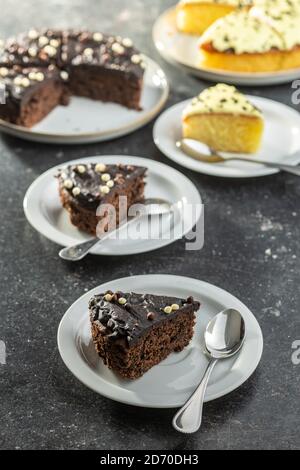 Stück Schokoladenkuchen auf Dessertplatte auf schwarzem Tisch. Stockfoto