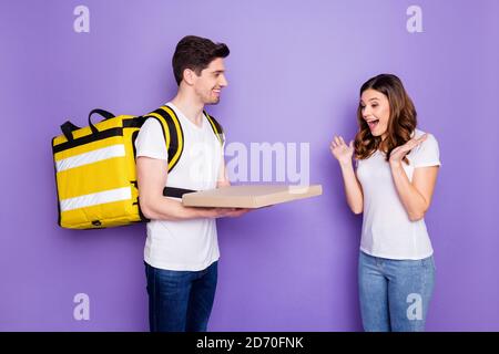 Portrait von schockiert Mädchen beeindruckt schnelle Pizza Pizzeria Express Lieferung Guy Kurier halten Box geben tragen weißen T-Shirt Denim Jeans Isoliert über violett Stockfoto