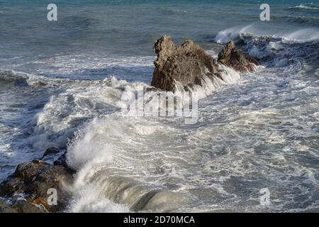 Stürmische Wellen krachen auf felsigen Strand namens Galeazza, Provinz Imperia, Ligurien, Nordwest-Italien Stockfoto