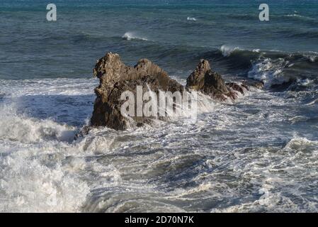 Stürmische Wellen krachen auf felsigen Strand namens Galeazza, Provinz Imperia, Ligurien, Nordwest-Italien Stockfoto
