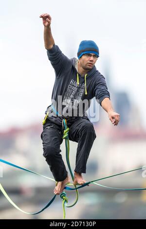 Ein Seiltänzer auf der Slacklinie über der Moldau mit Panorama auf die Prager Burg, Tschechische republik Stockfoto