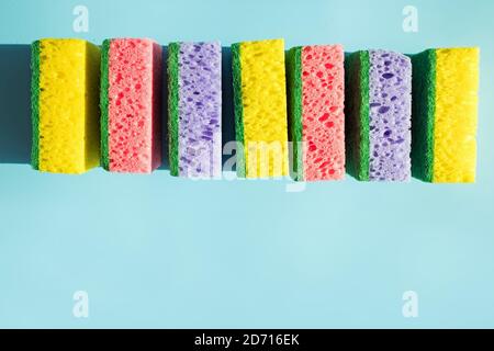 Bunte Schwämme für Geschirr isoliert auf blauem Hintergrund. Stockfoto