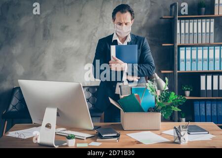 Foto von traurigen Arbeiter reifen Kerl Manager Verlierer halten Umarmung Tagebuch Pack Habseligkeiten Karton Personal Box Tisch Büro Desktop drinnen Stockfoto